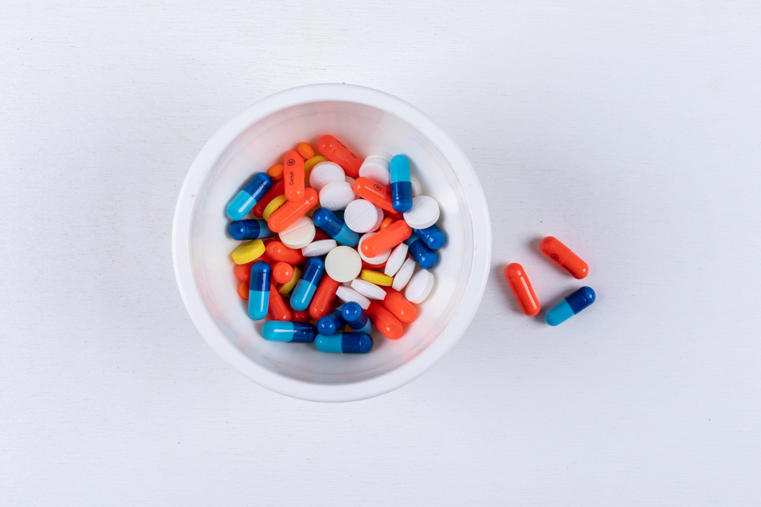 Buy Top view pills in bowl on white background. horizontal online
